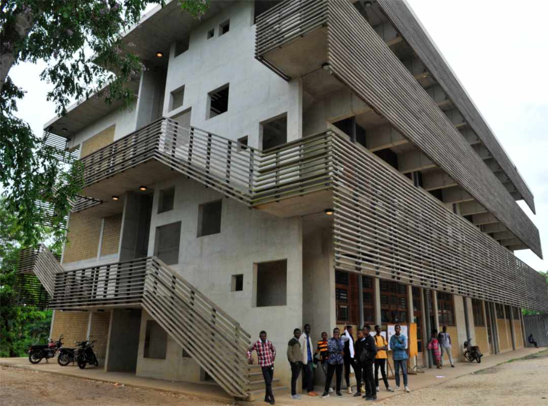 een aantal studenten voor het gebouw van de universiteit van Kisangani.